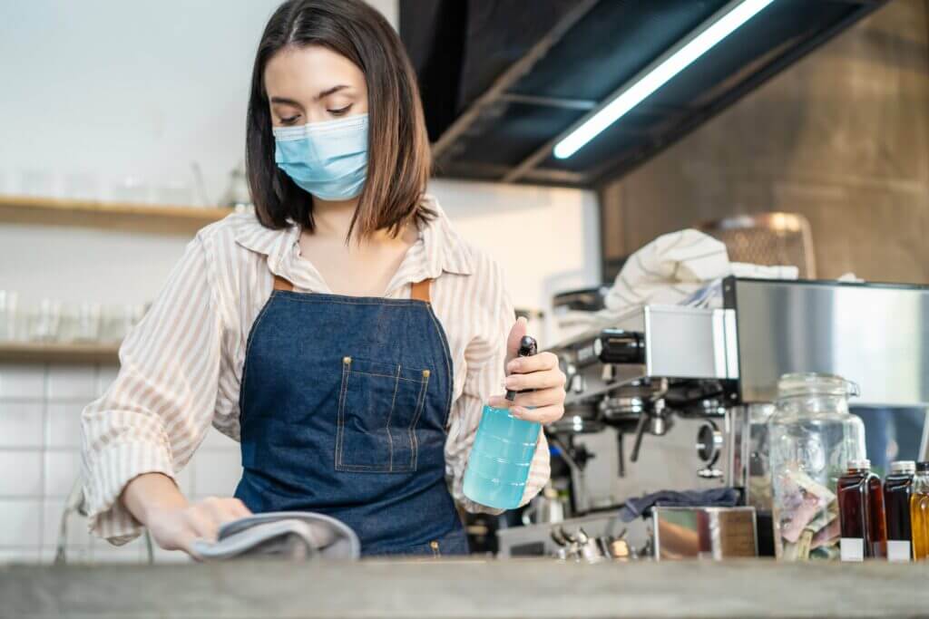 Woman disinfecting a food prep area