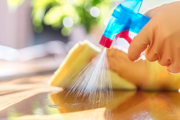 Spraying cleanser on a table surface